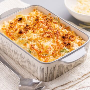A casserole dish with cheese and broccoli on a napkin.