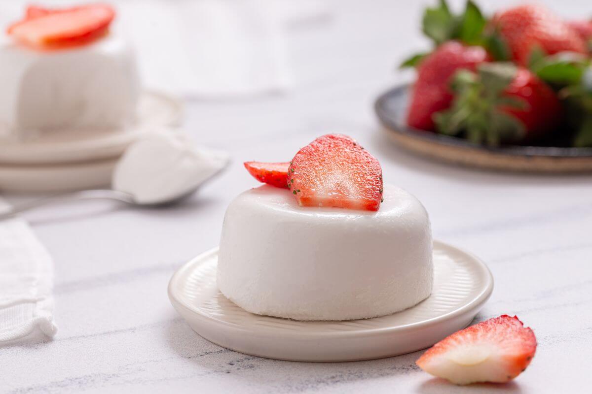 Coconut panna cotta with strawberries on a plate.