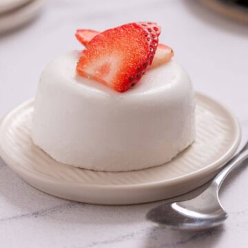 A panna cotta with a strawberry on top.
