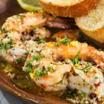 Grilled shrimp with garlic and herbs served with slices of toasted bread.