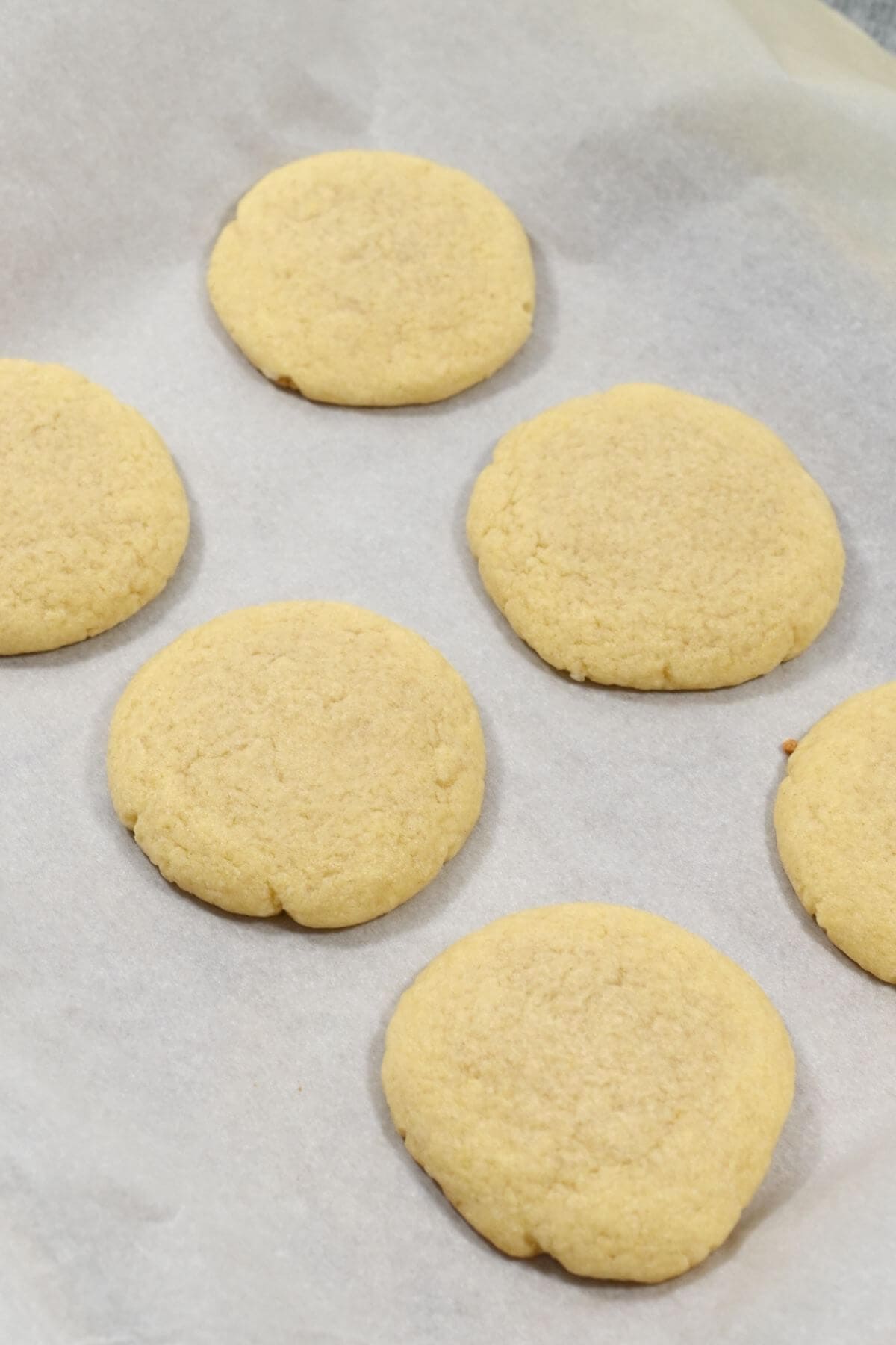 Freshly baked cookies cooling on parchment paper.