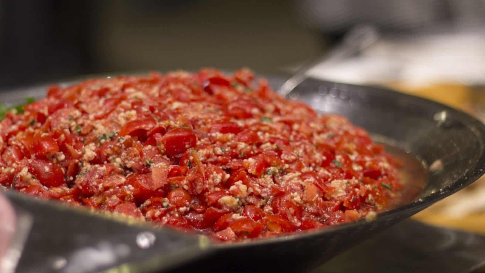 A close-up of a metal bowl filled with salsa.