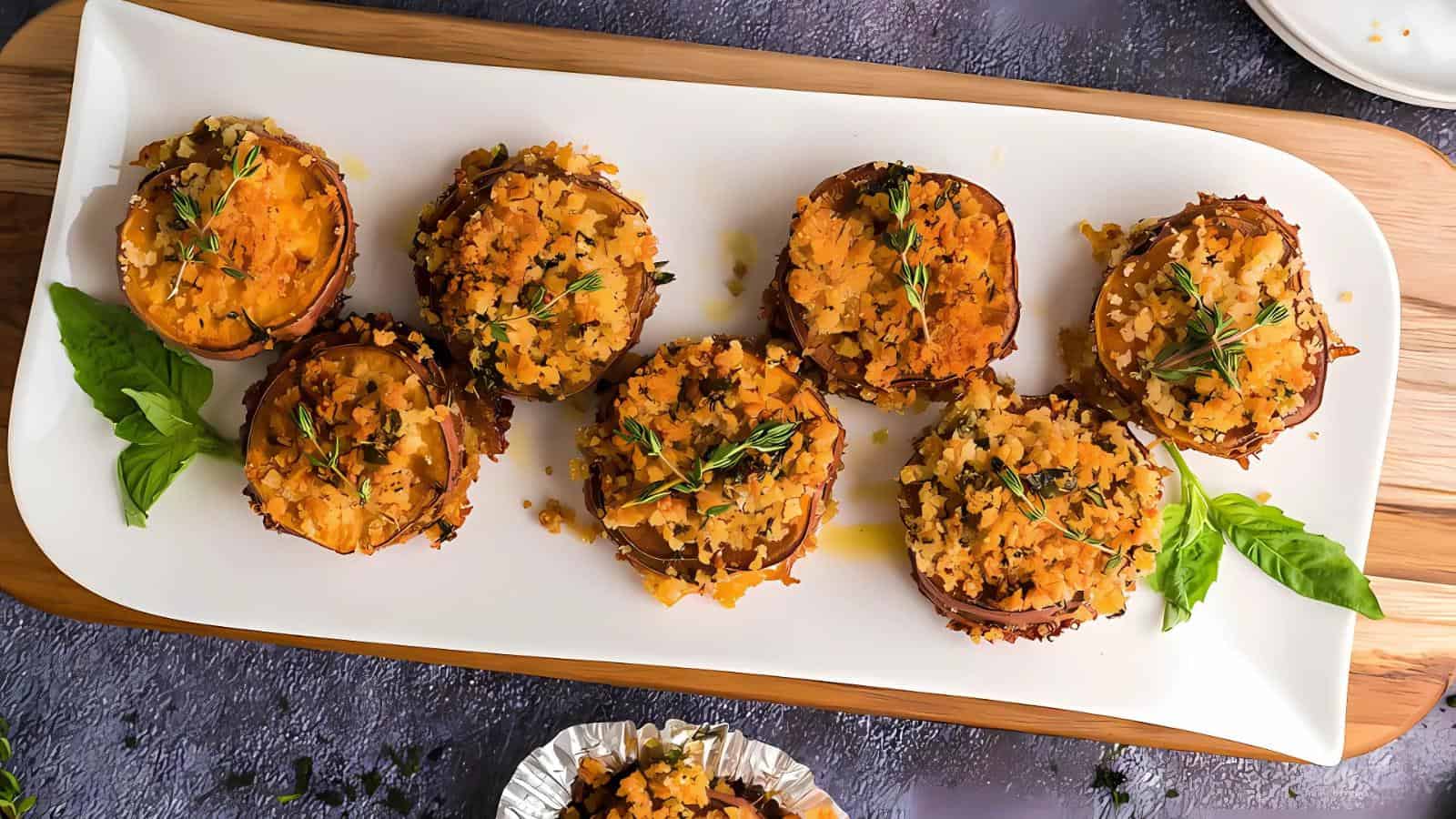 A plate of stuffed mushrooms topped with breadcrumbs and herbs, garnished with fresh basil.
