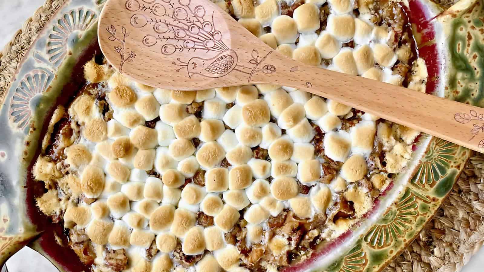 Dessert topped with toasted marshmallows, with a wooden spoon resting on top.