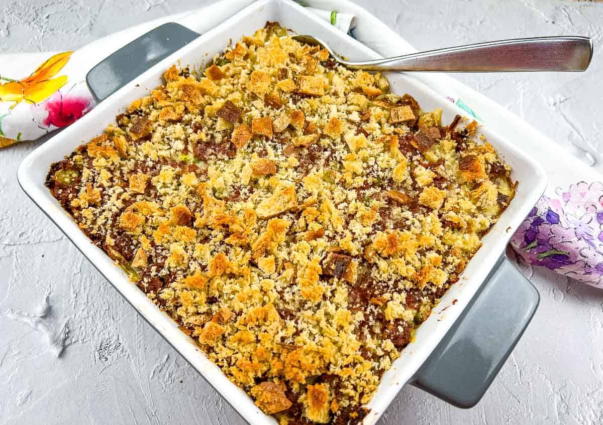 A baked casserole dish with a crumbly breadcrumb topping, served with a metal serving spoon—these casseroles taste like a chef made them, but you did.