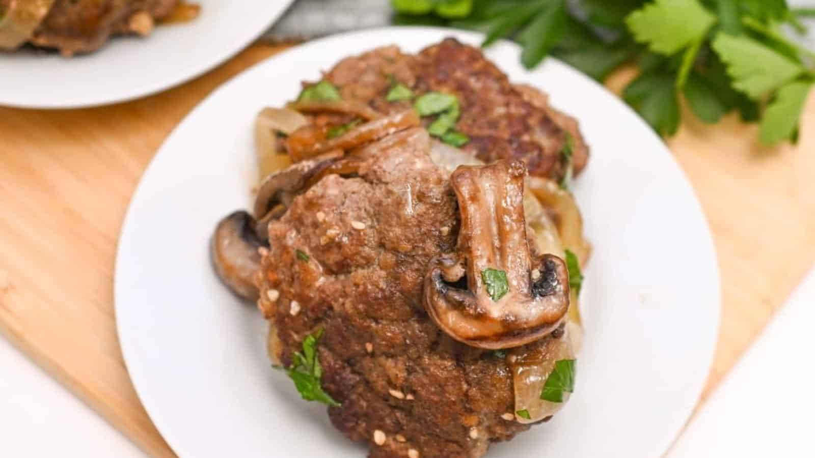 Plate of cooked meatloaf topped with sautéed mushrooms and garnished with parsley.