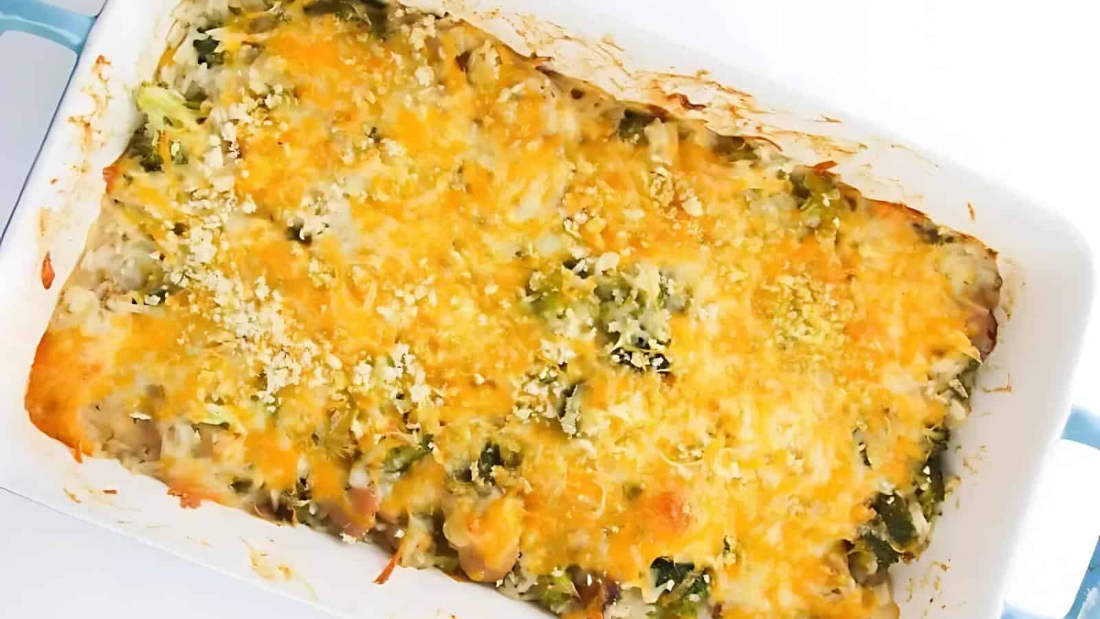 A baked casserole topped with melted cheese and breadcrumbs in a white rectangular dish.