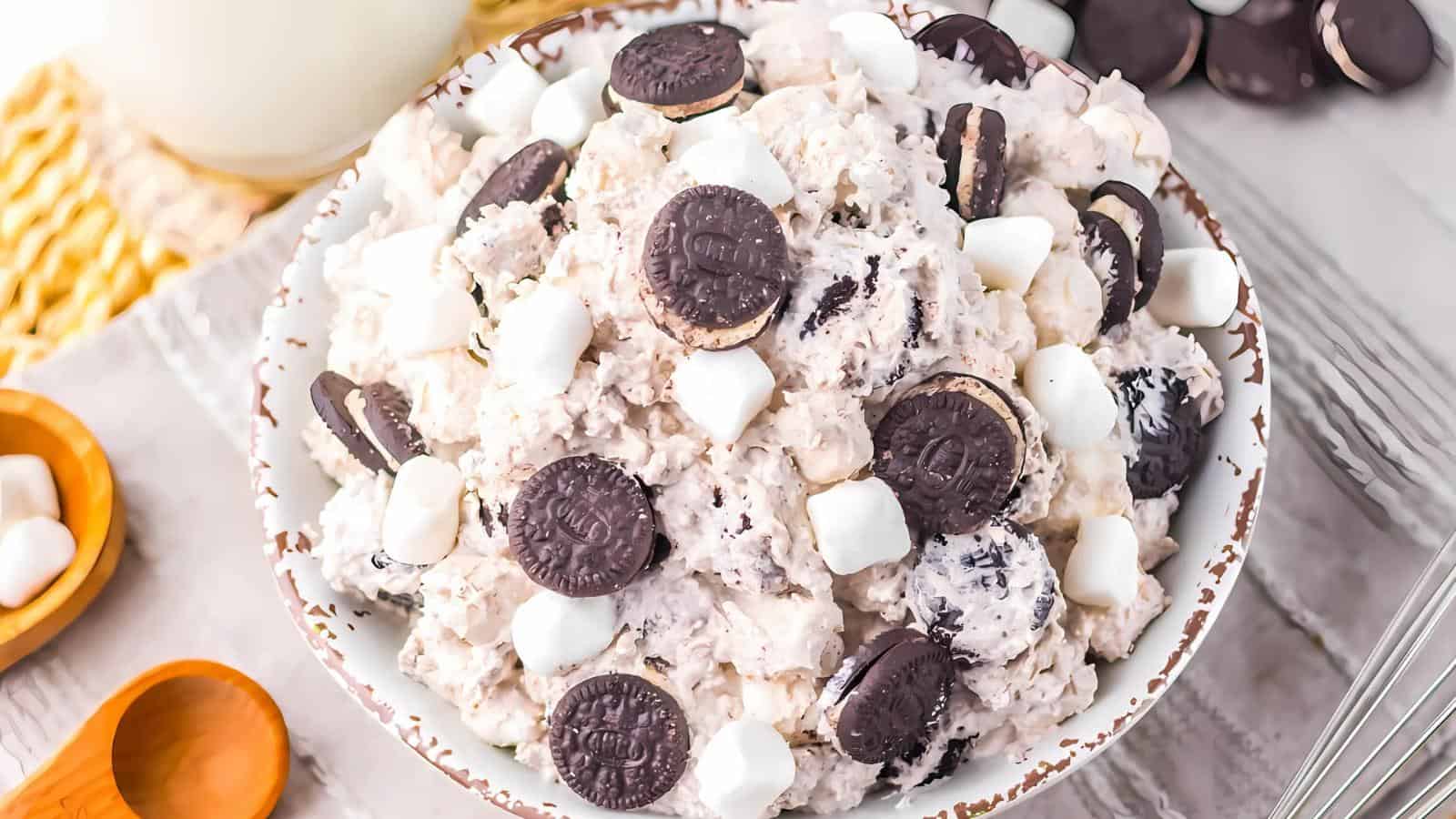 A bowl filled with a dessert mixture containing mini chocolate sandwich cookies and small marshmallows.