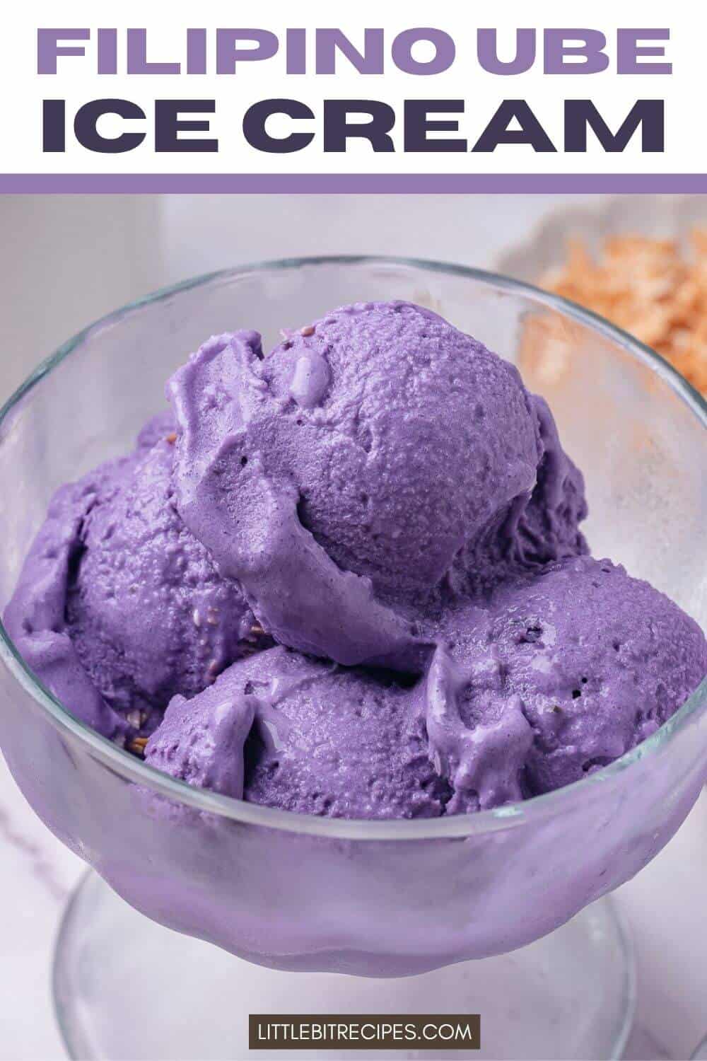 A glass bowl filled with three scoops of purple Filipino ube ice cream, with a partial view of a crunchy topping in the background.