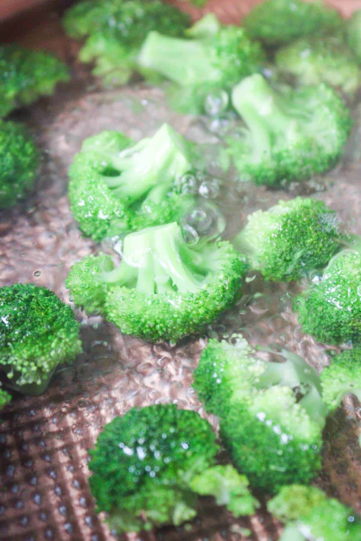 Broccoli florets being blanched in boiling water.